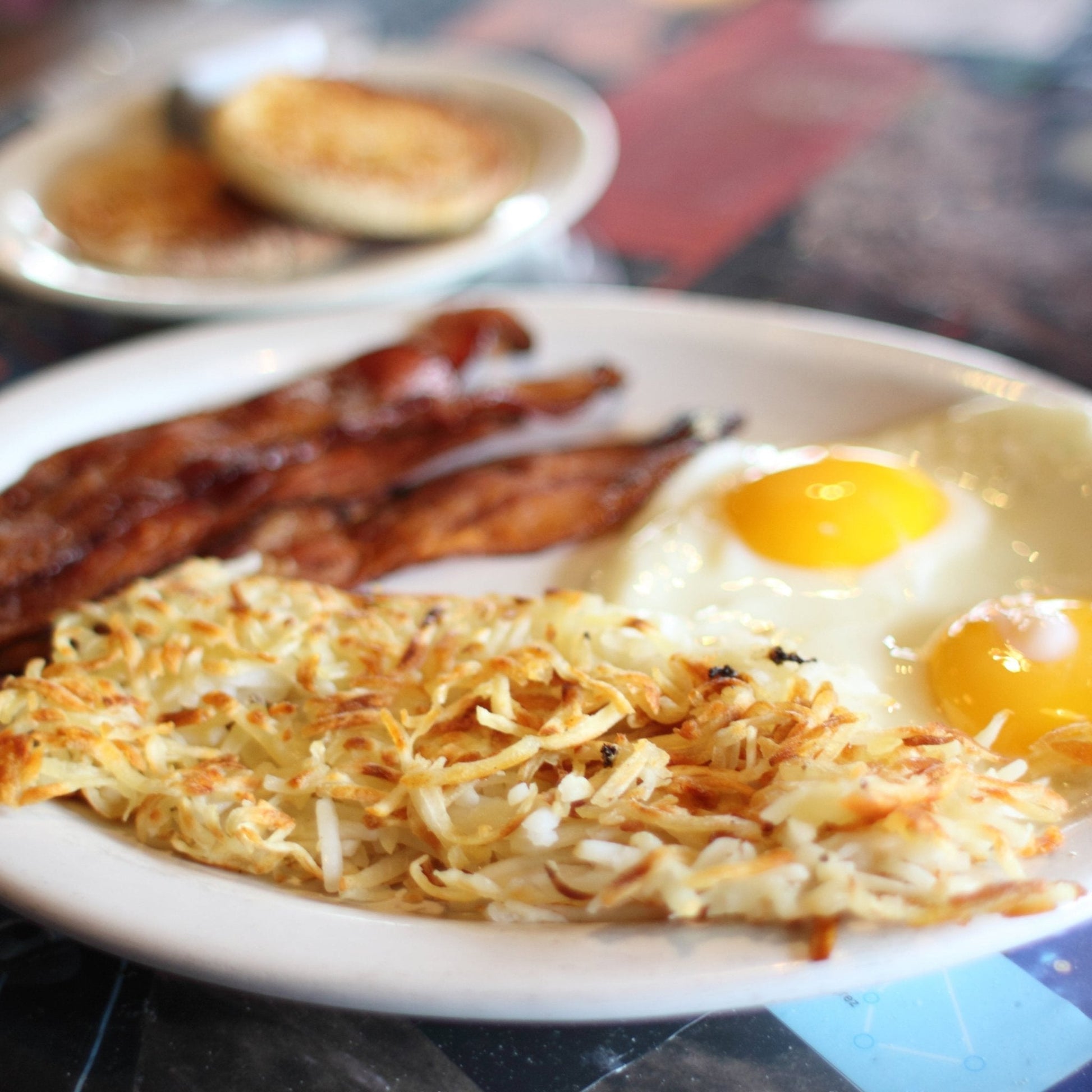 Augason Farms hashbrown potatoes pouch with 6 servings, showing golden-brown cooked hashbrowns on a plate.