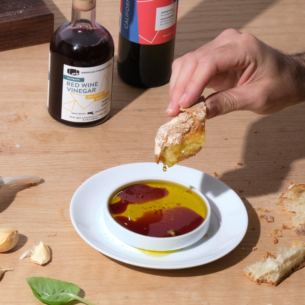 American Vinegar Works California organic extra virgin olive oil being drizzled over fresh bread for dipping