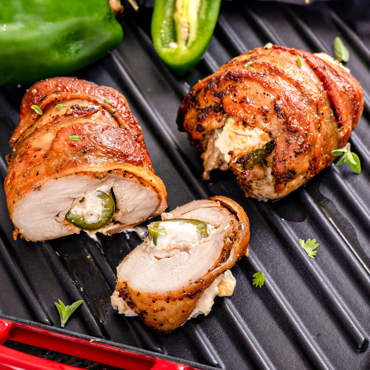 Bacon-wrapped stuffed chicken breasts cut open, showing juicy meat and flavorful filling, prepared by Pig of the Month BBQ.