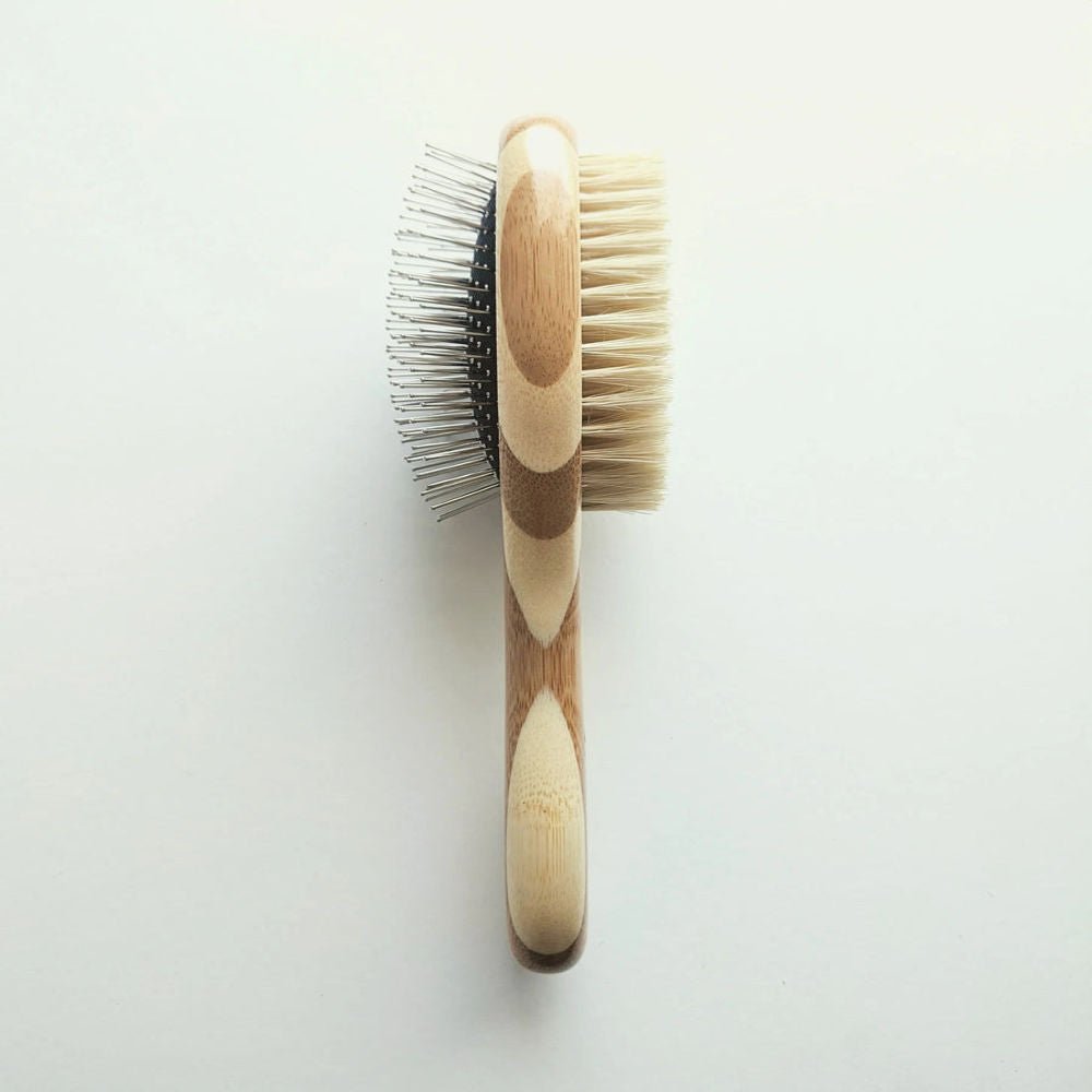 Double-sided Tilley + Me dog grooming brush with bamboo handle, featuring bristle and wire sides for shedding and detangling.