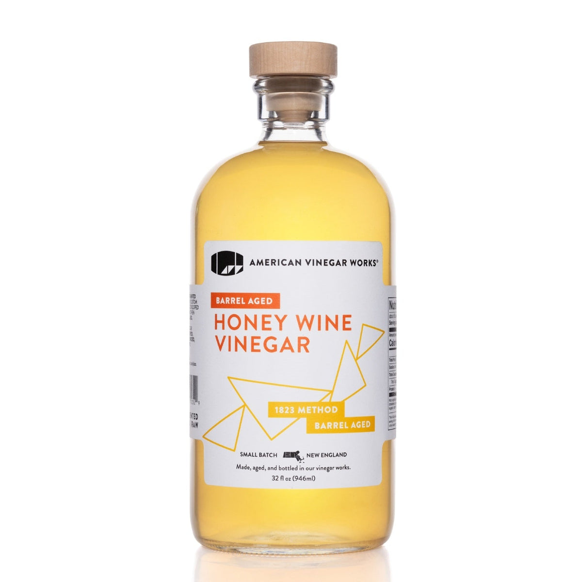 Barrel-aged honey wine vinegar from American Vinegar Works in a glass bottle, showcasing its rich amber color and smooth texture.