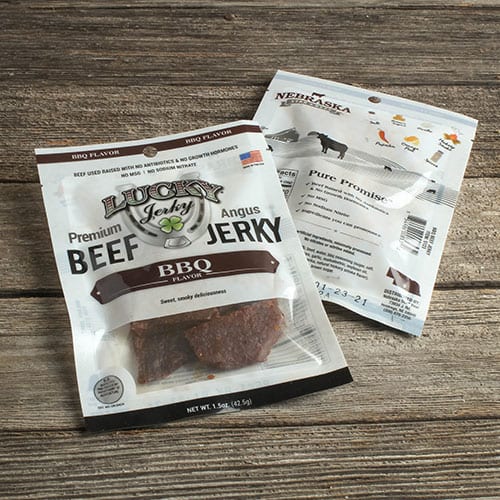 Thin slices of BBQ-flavored Nebraska Star Beef Jerky in a 1.5 oz package, showcasing savory beef jerky on a white background.