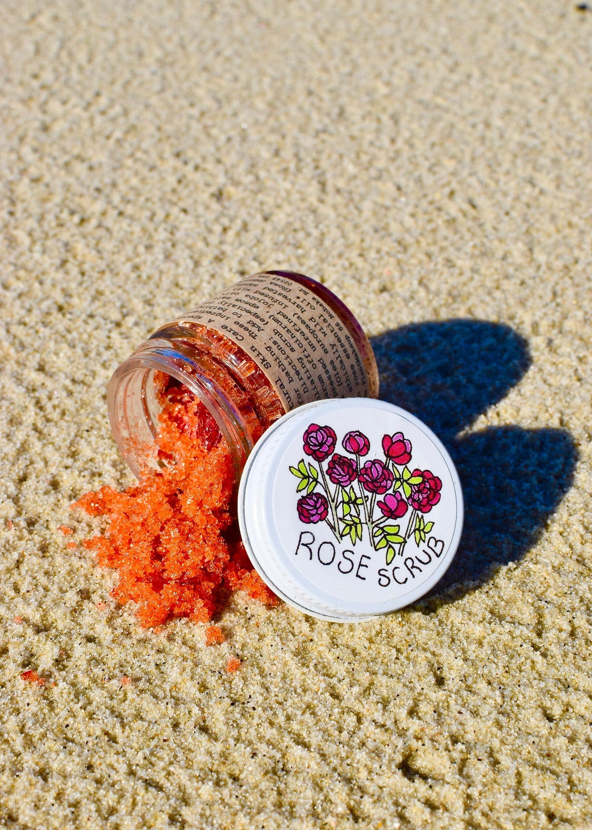 Plant Makeup Beach Rose Scrub with natural exfoliating beads in a clear jar, featuring pink rose petals and a creamy texture.