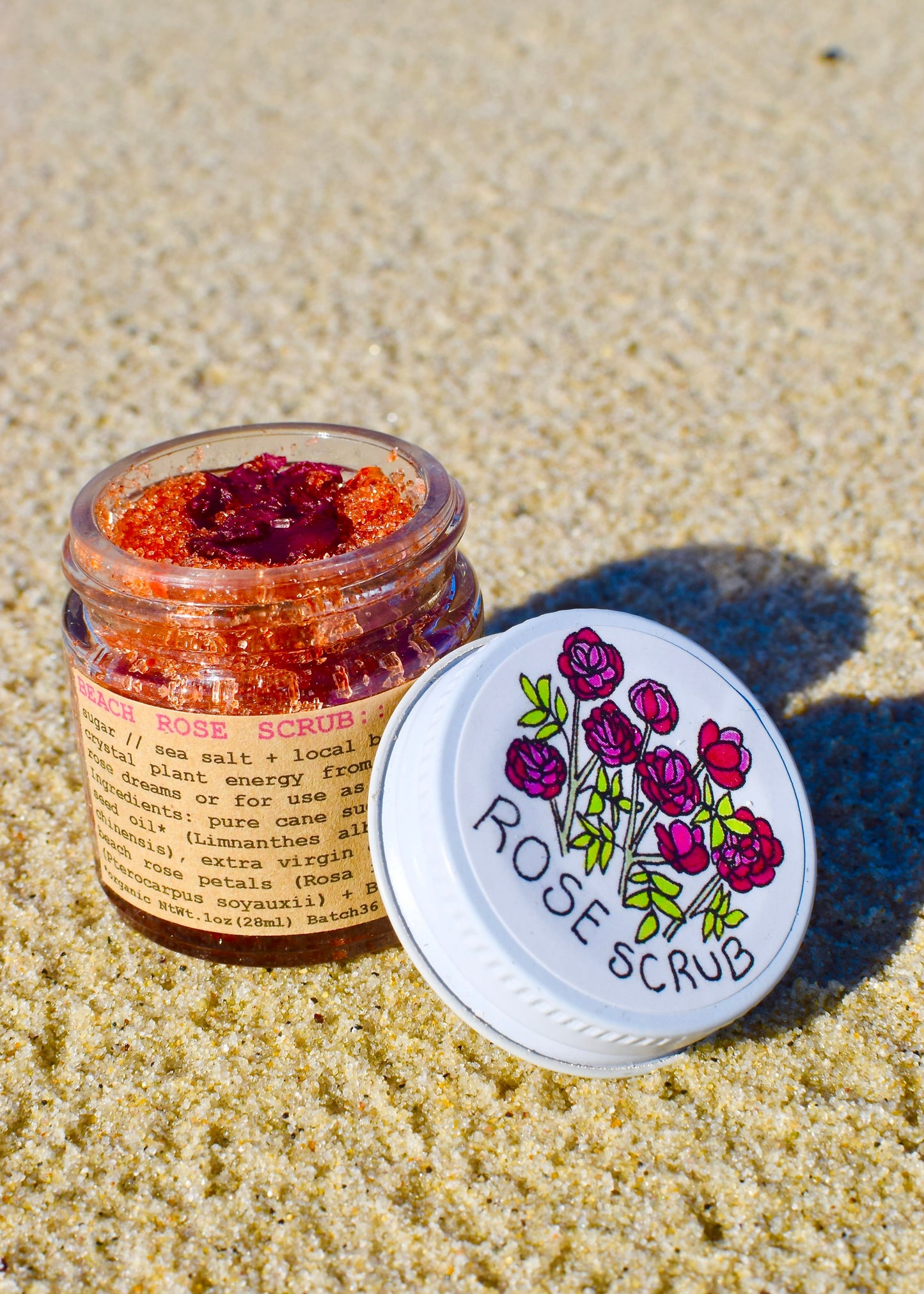 Plant Makeup Beach Rose Scrub in a jar with a textured surface, showcasing natural exfoliating ingredients and floral accents.