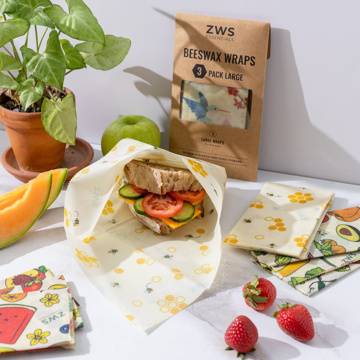 Three large beeswax food wraps for sandwiches, made by ZeroWasteStore.com, showcasing natural beeswax coating and vibrant fabric patterns.