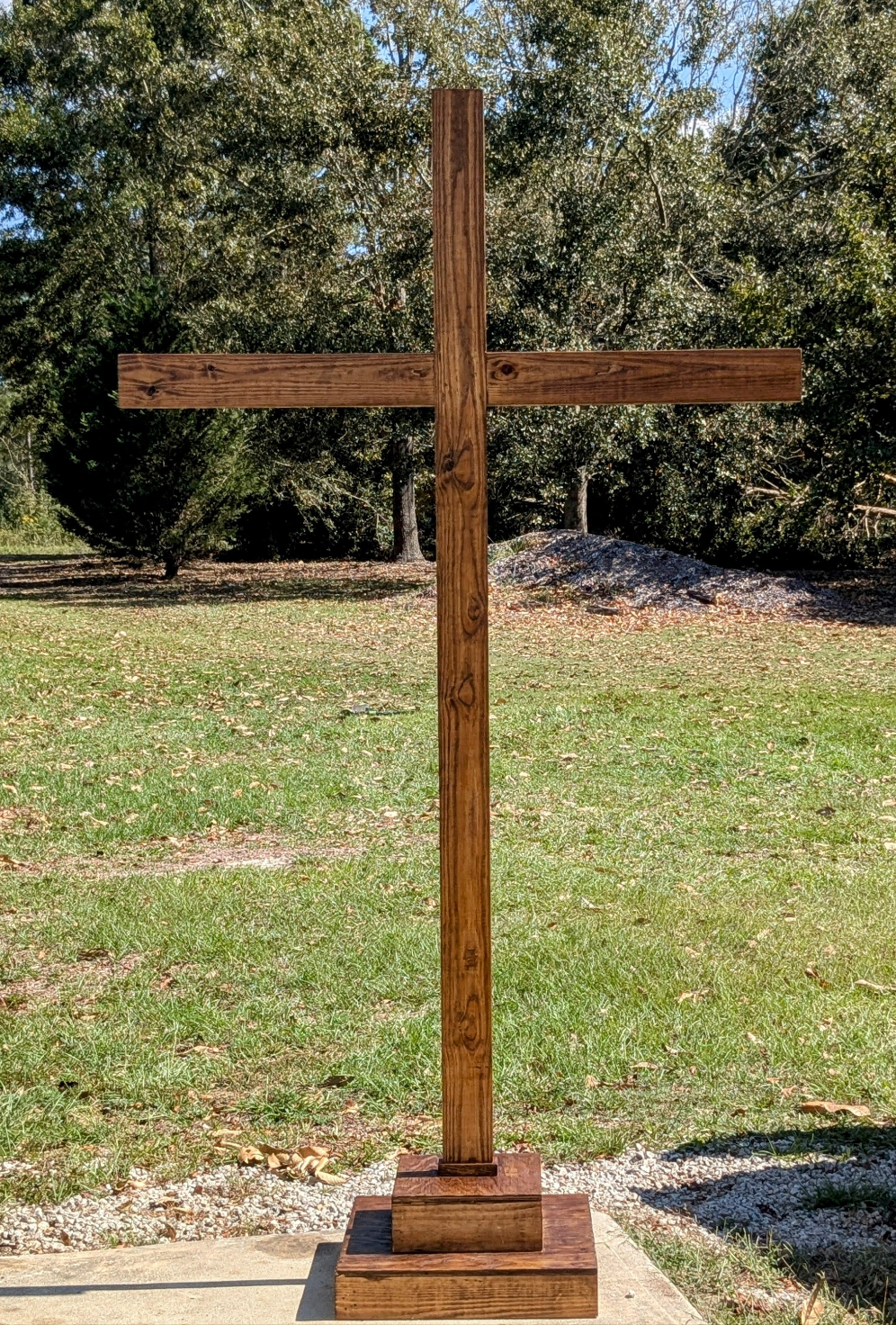 7-foot wooden mahogany ceremonial cross for events, displayed on a stand, suitable for religious ceremonies and gatherings.