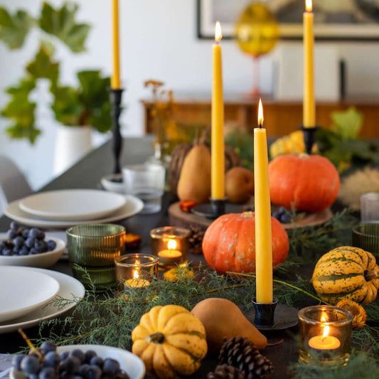 Bluecorn Beeswax Taper Candles on a Thanksgiving table with tea light candles, showcasing natural hand-dipped taper candles in a bundle.