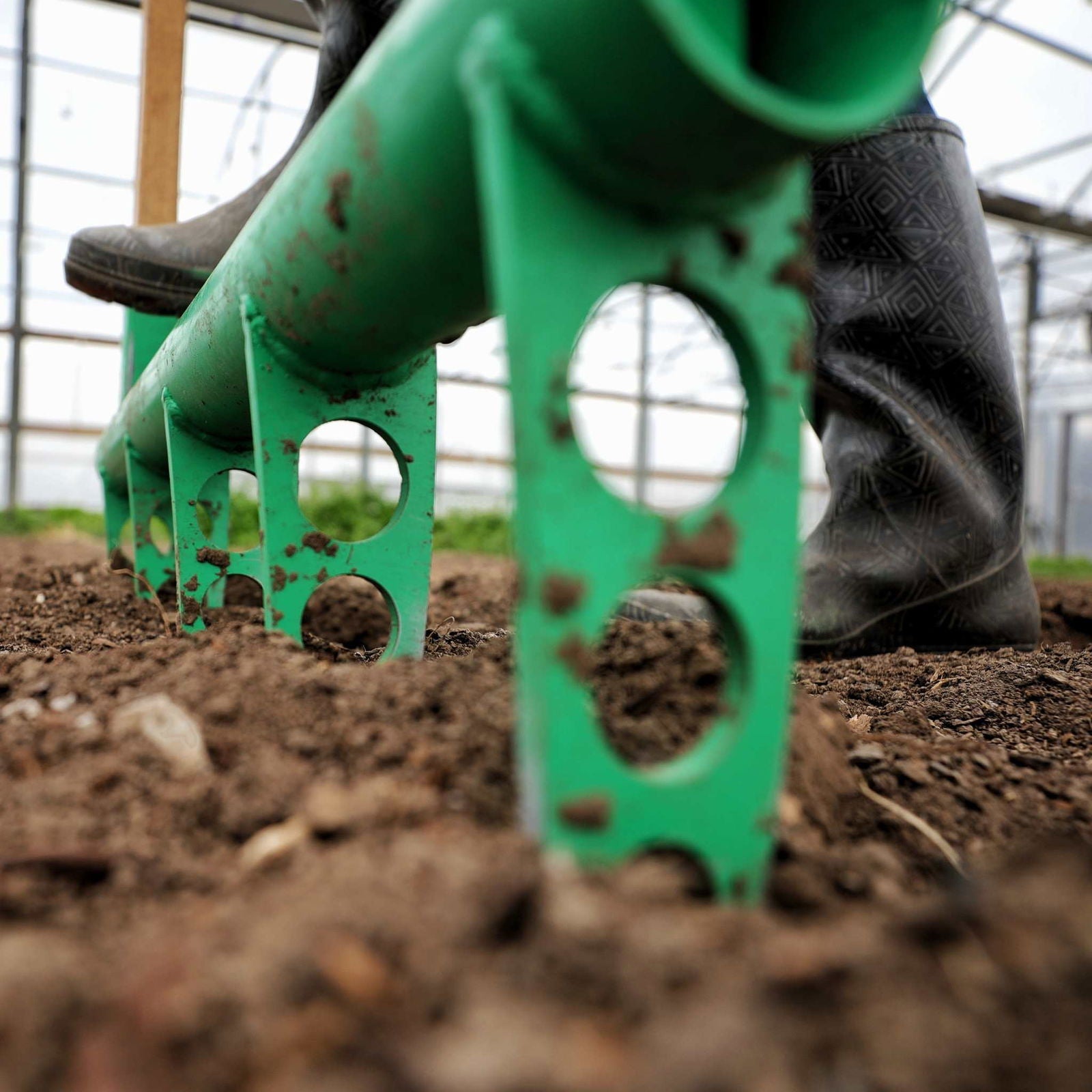 Bootstrap Farmer broadfork garden tool, USA-made, with sturdy tines for aerating soil in a garden setting.
