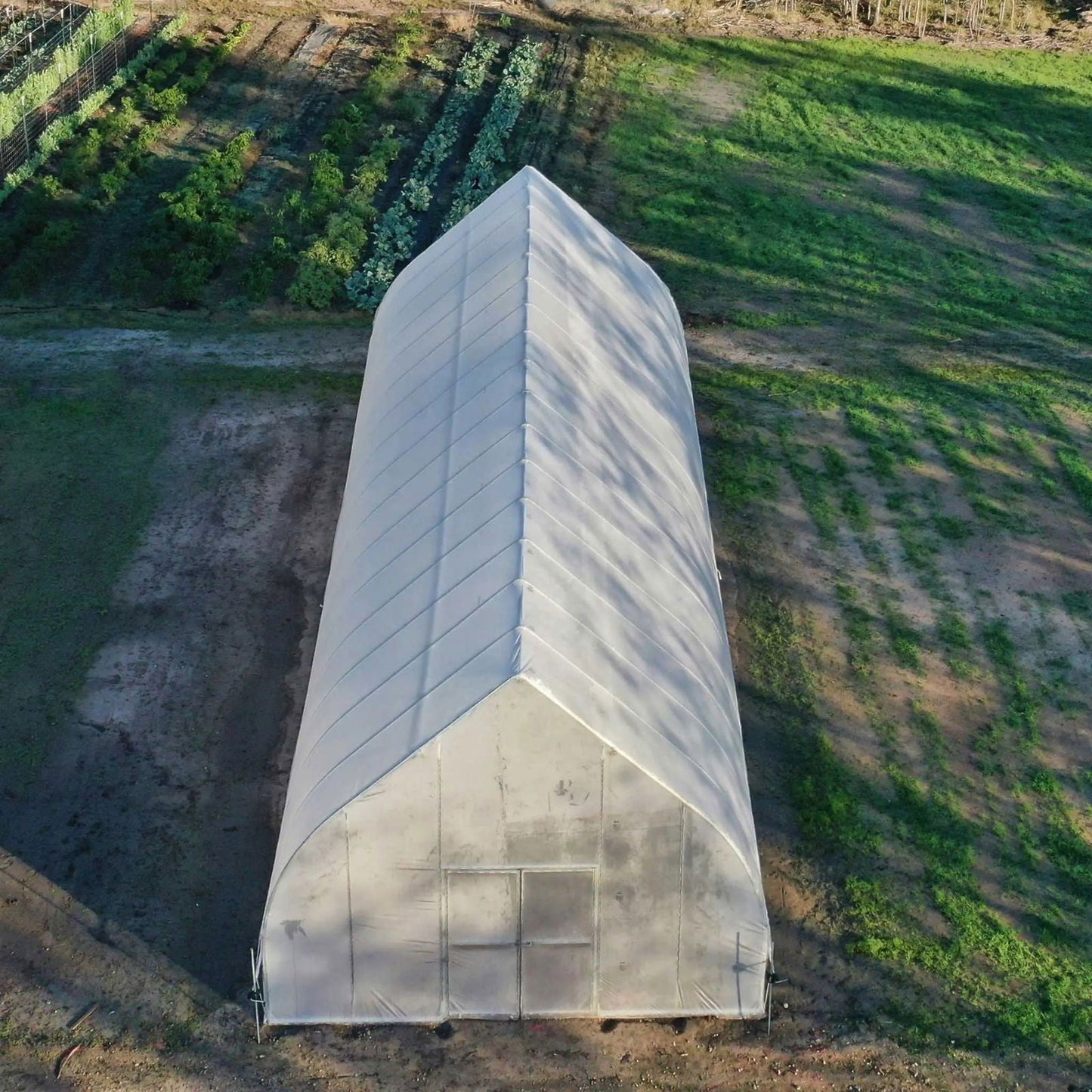 Gothic all-metal hoop house greenhouse kit by Bootstrap Farmer, showcasing sturdy metal arches and transparent cover for plant growth.