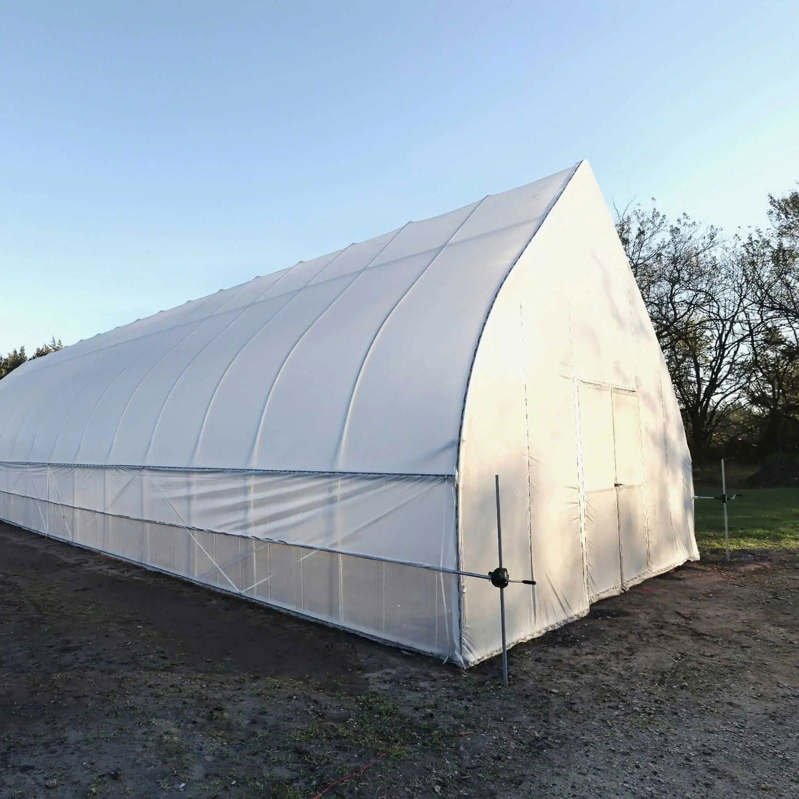 Gothic all-metal hoop house kit by Bootstrap Farmer, a sturdy greenhouse kit with metal frame and transparent covering.