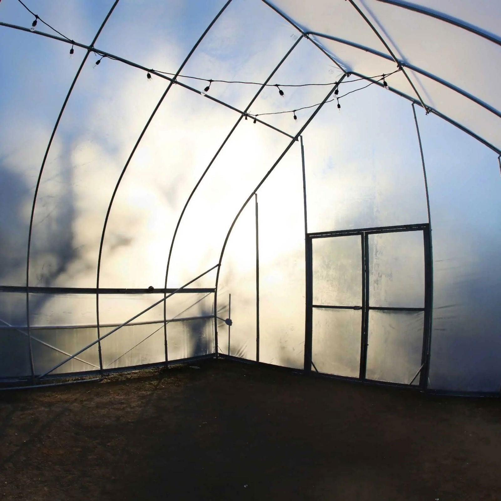 Greenhouse kit featuring gothic all-metal hoop house design by Bootstrap Farmer, with sturdy metal frame and transparent cover.