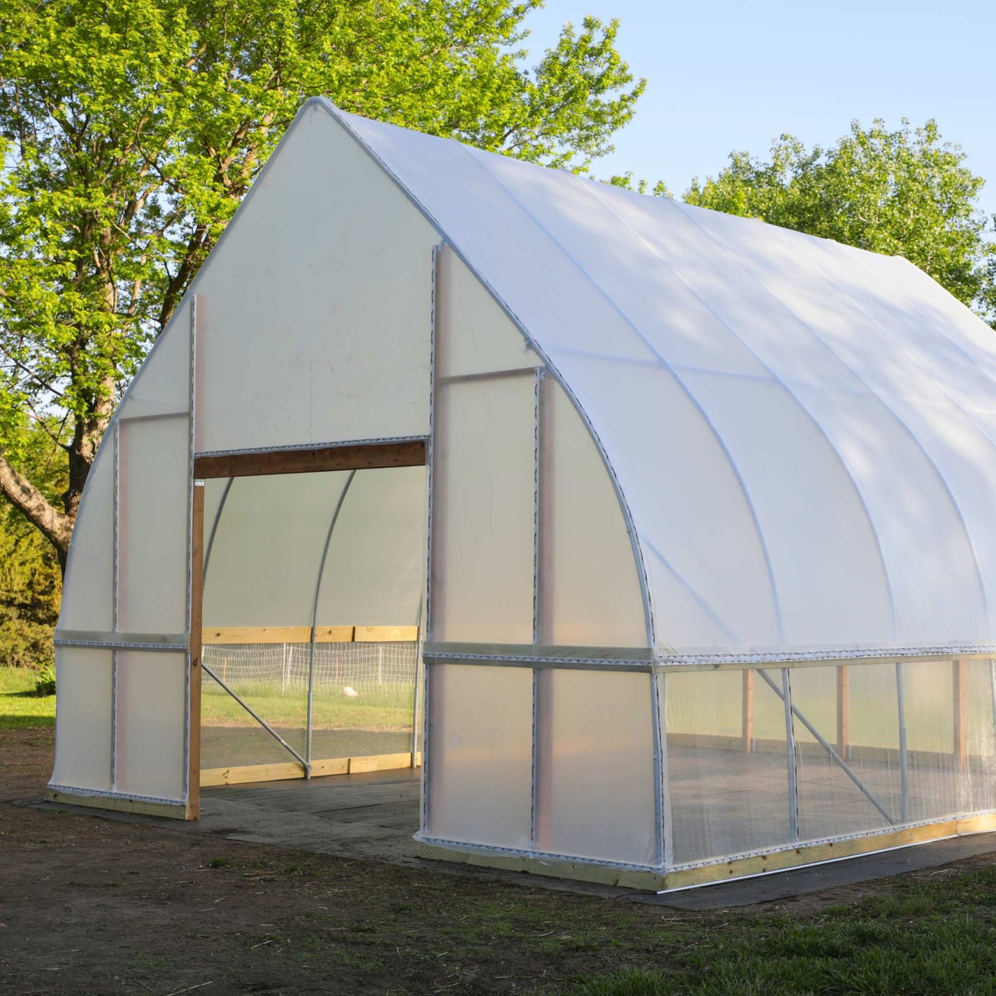 DIY Gothic Greenhouse Kit by Bootstrap Farmer featuring a sturdy green metal frame and clear panels for plant cultivation.