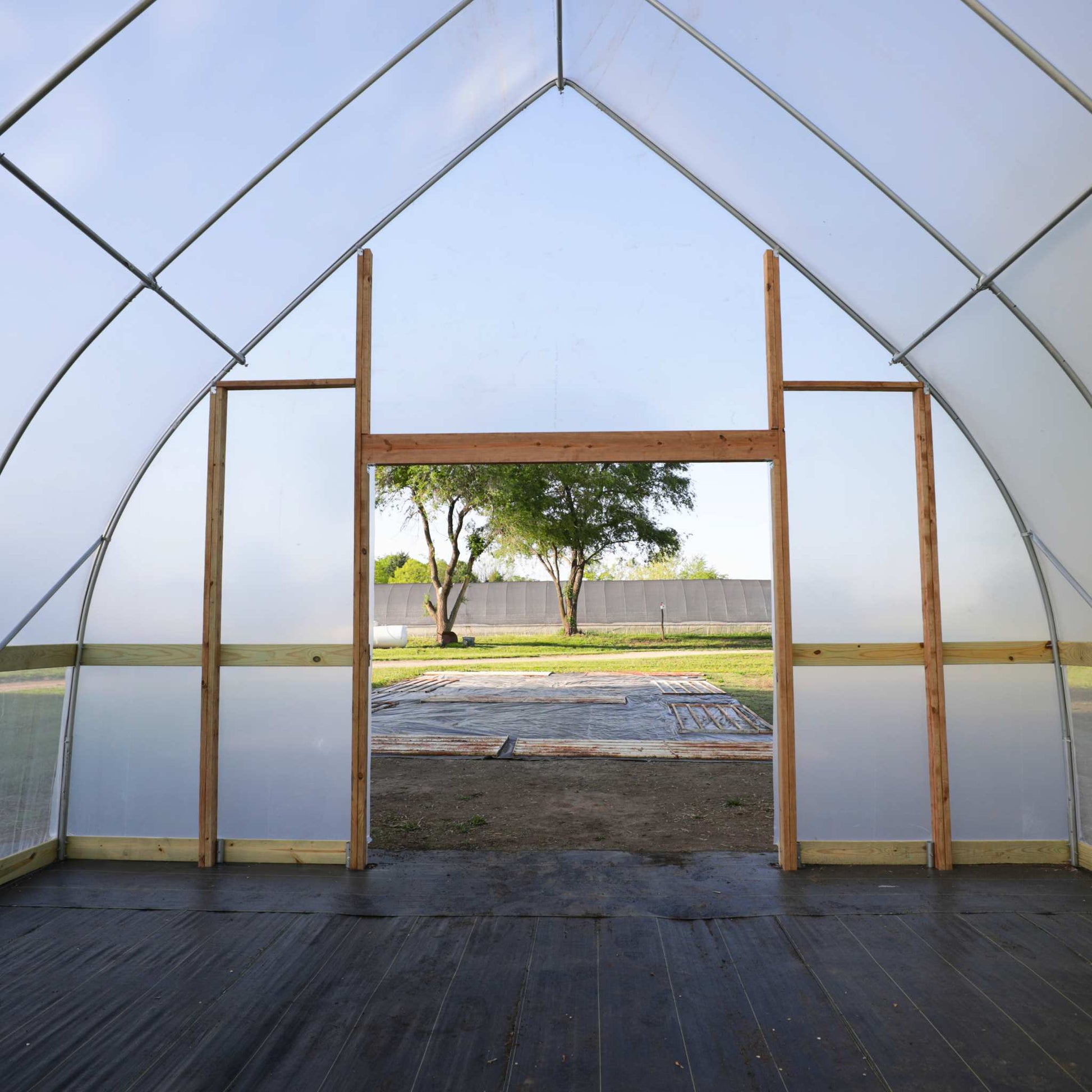 DIY Gothic Greenhouse Kit by Bootstrap Farmer features sturdy green structure with clear panels for optimal plant growth.
