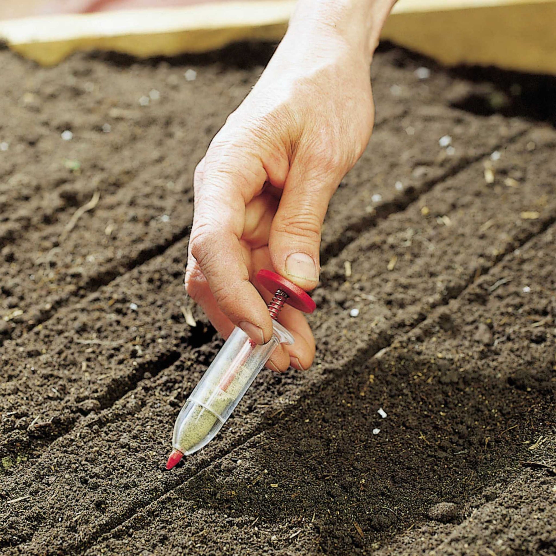 Luster Leaf Rapiclip Mini-Seedmaster 805 from Bootstrap Farmer, close-up of the compact seed planting tool in use.