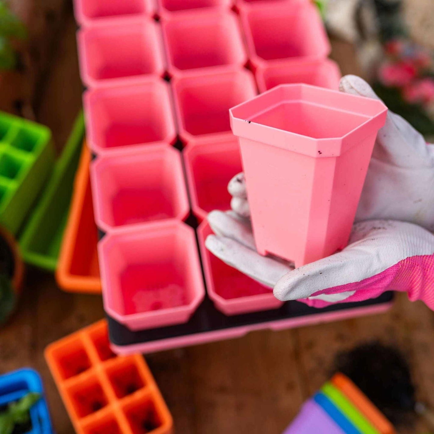 Multicolored Bootstrap Farmer pots with humidity domes from the Ultimate Backyard Gardener Bundle for planting and gardening.