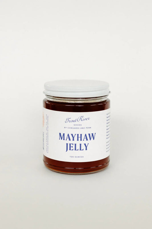 Jar of Congaree and Penn Mayhaw Jelly with a clear label, showcasing a smooth, amber-colored fruit jelly on a white background.