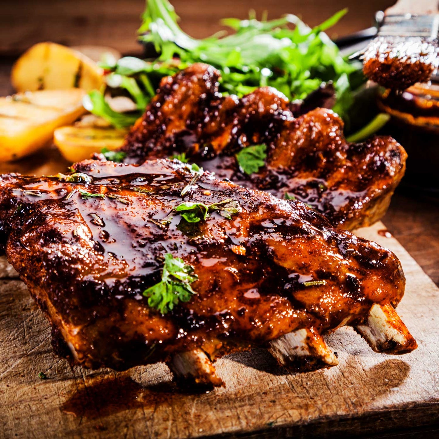 Barbecue ribs glazed with candied orange from Pig of the Month BBQ, showing juicy, tender ribs with a citrusy glaze.