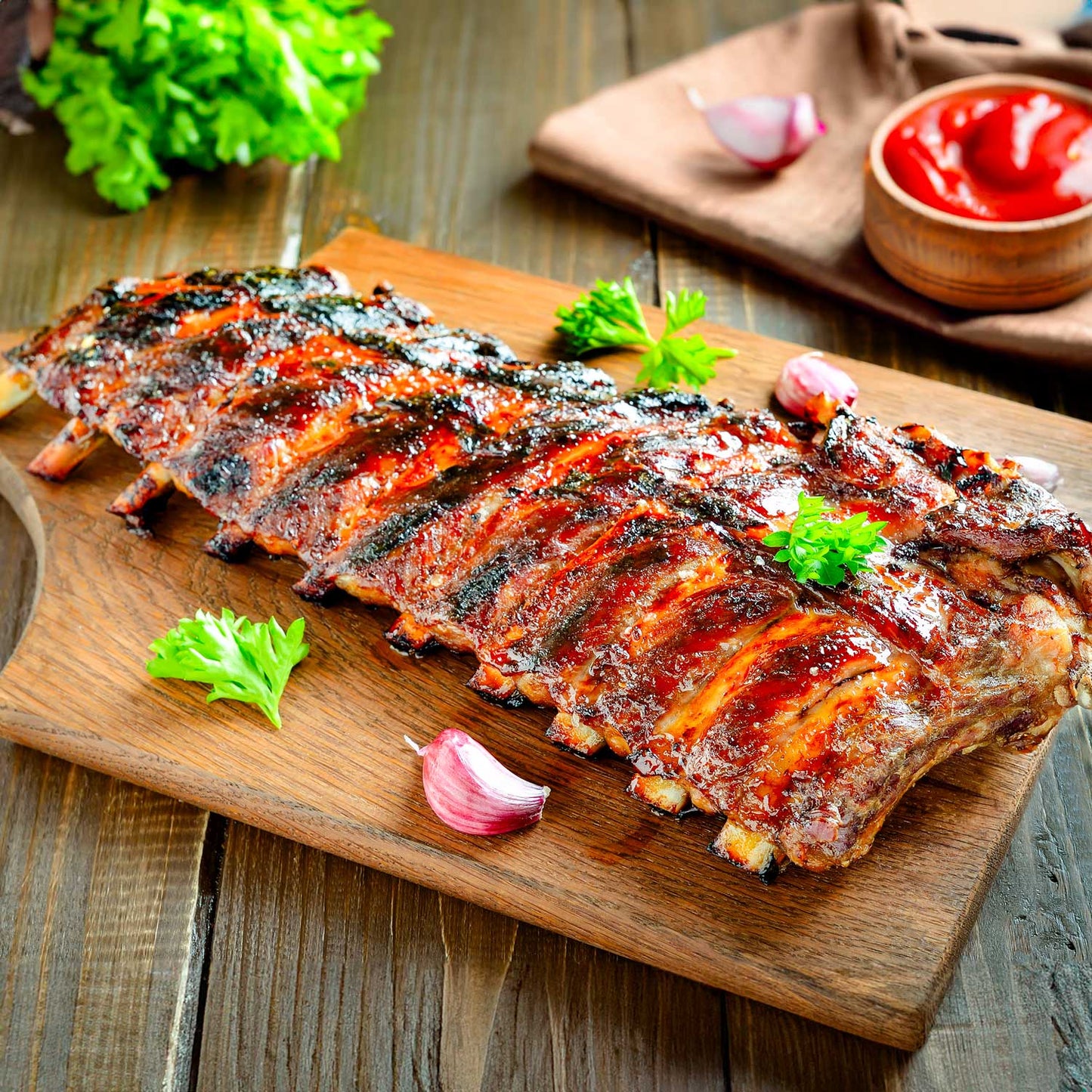 Juicy BBQ ribs with candied orange glaze from Pig of the Month BBQ, shown topped with orange slices and served on a platter.