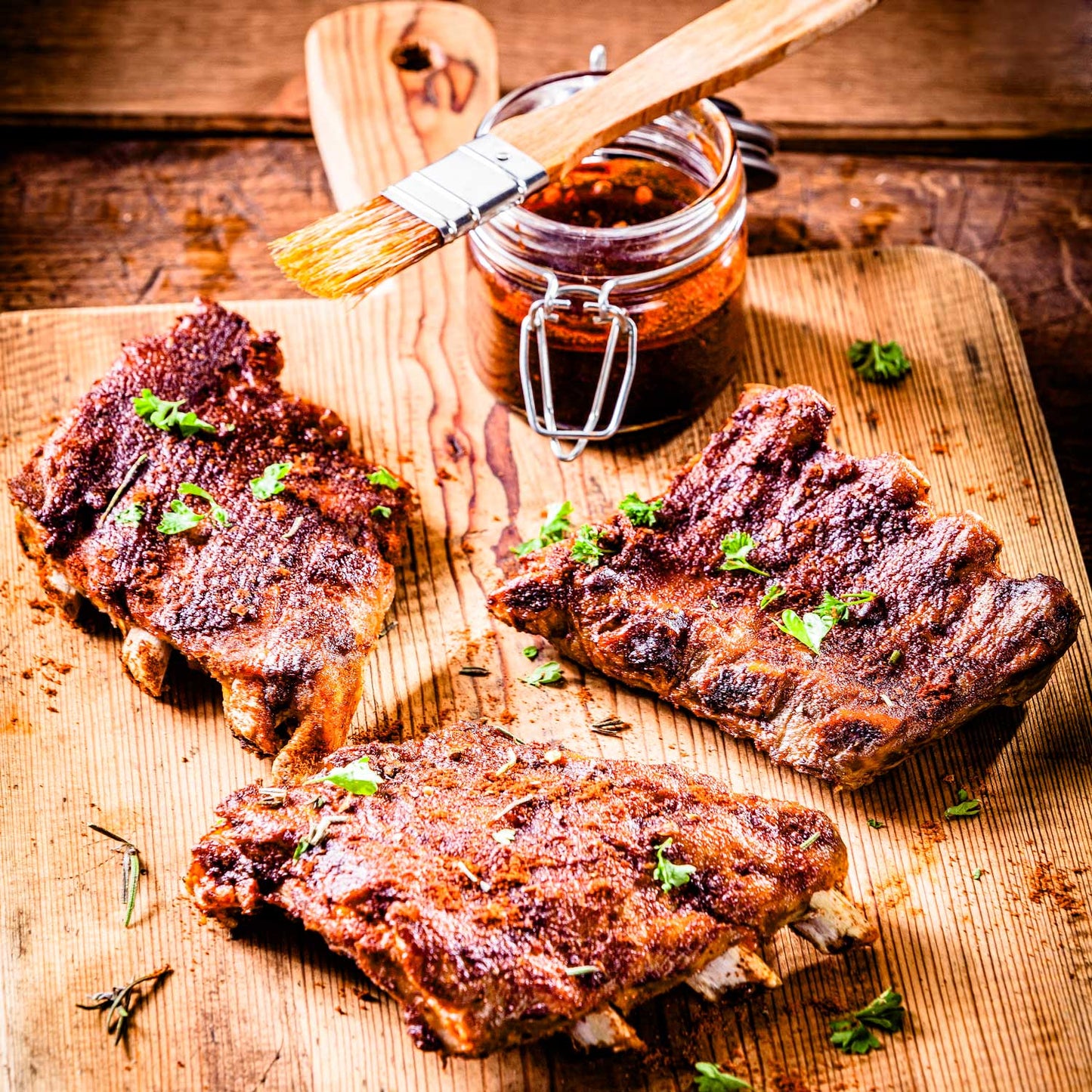 Juicy BBQ ribs glazed with candied orange from Pig of the Month BBQ, showing tender meat and vibrant orange glaze.