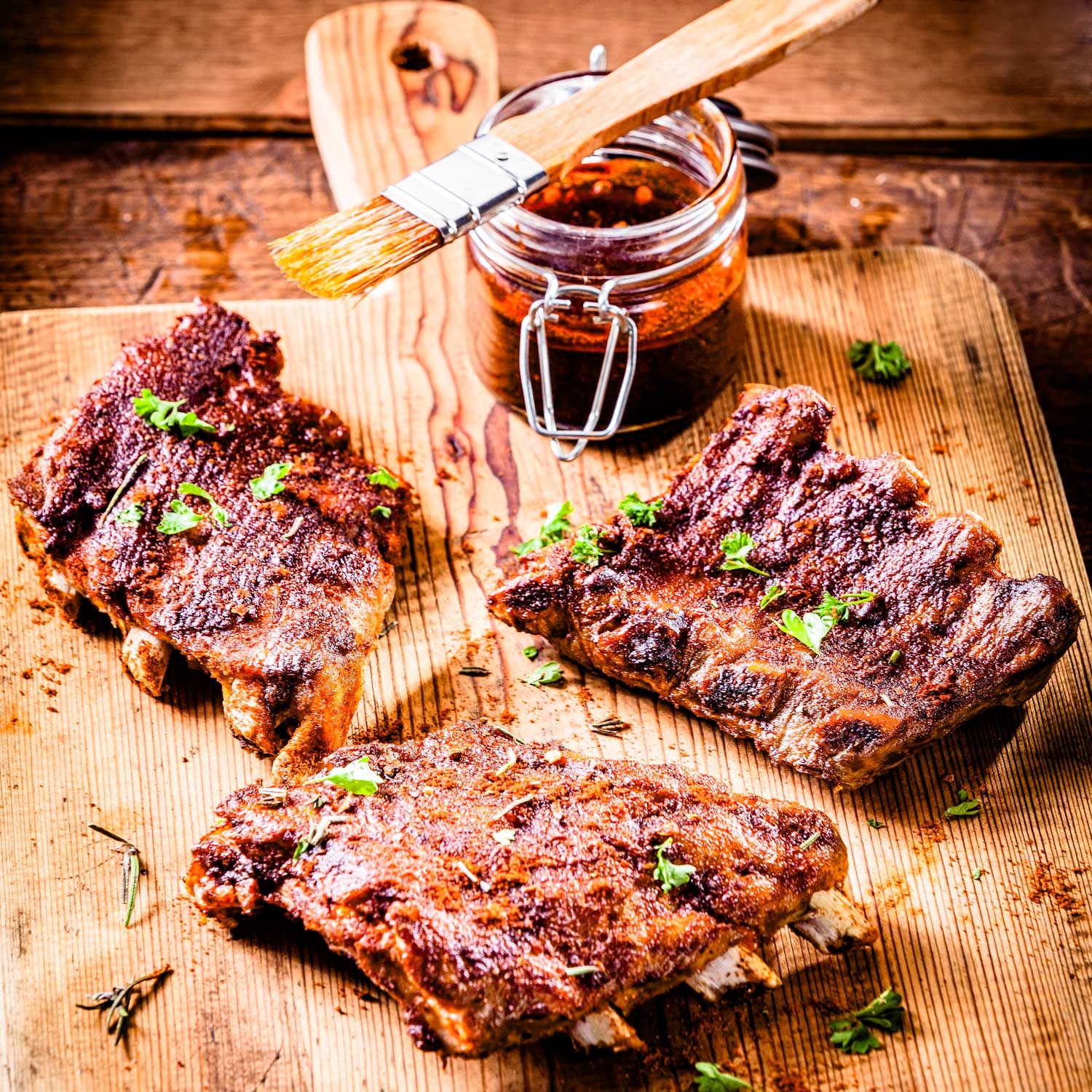 Juicy BBQ ribs glazed with candied orange from Pig of the Month BBQ, showing tender meat and vibrant orange glaze.