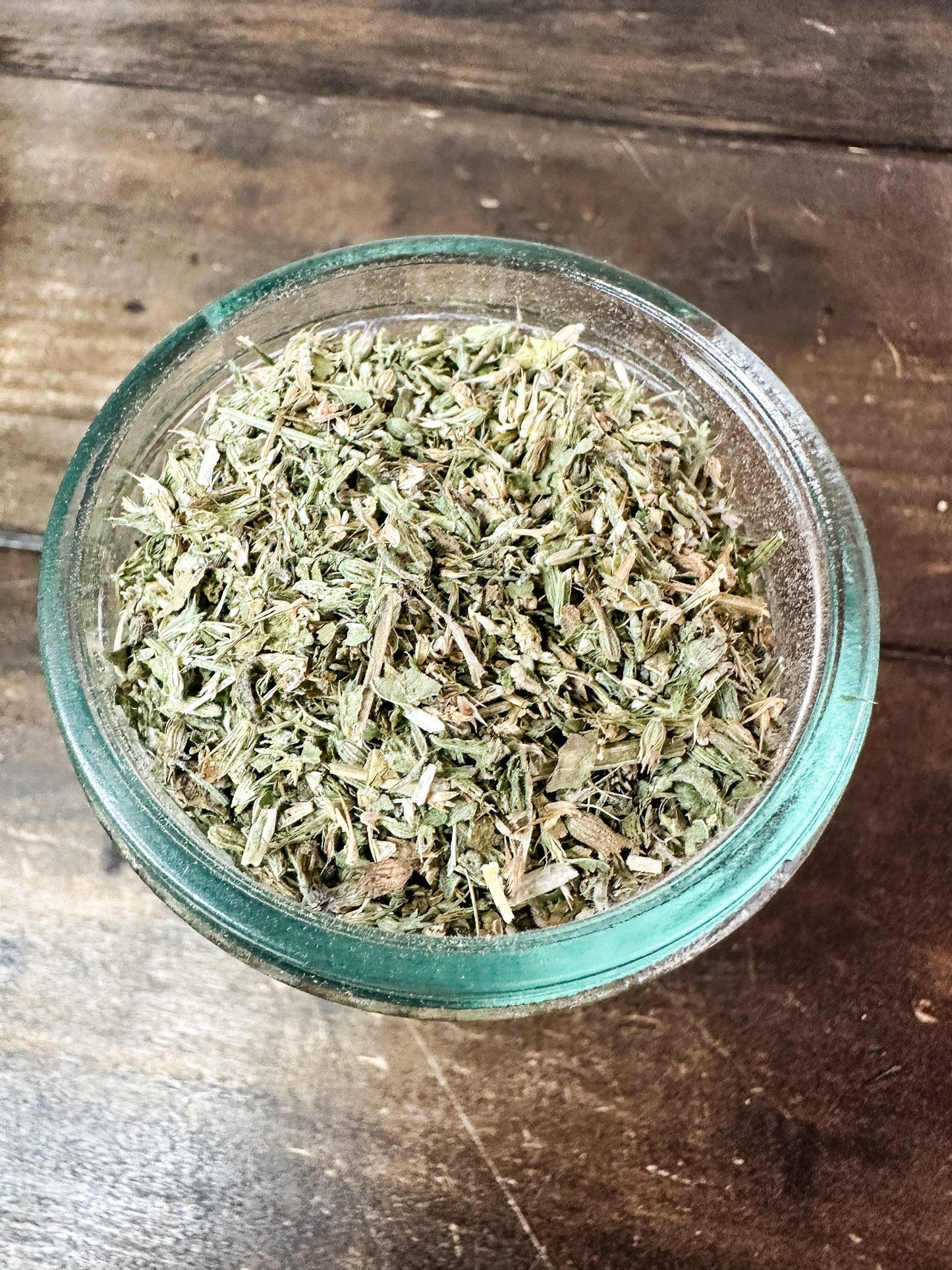Small jar of dried catnip herbs from herbalroseapothecary, showcasing fresh green herb leaves in a compact herb jar.
