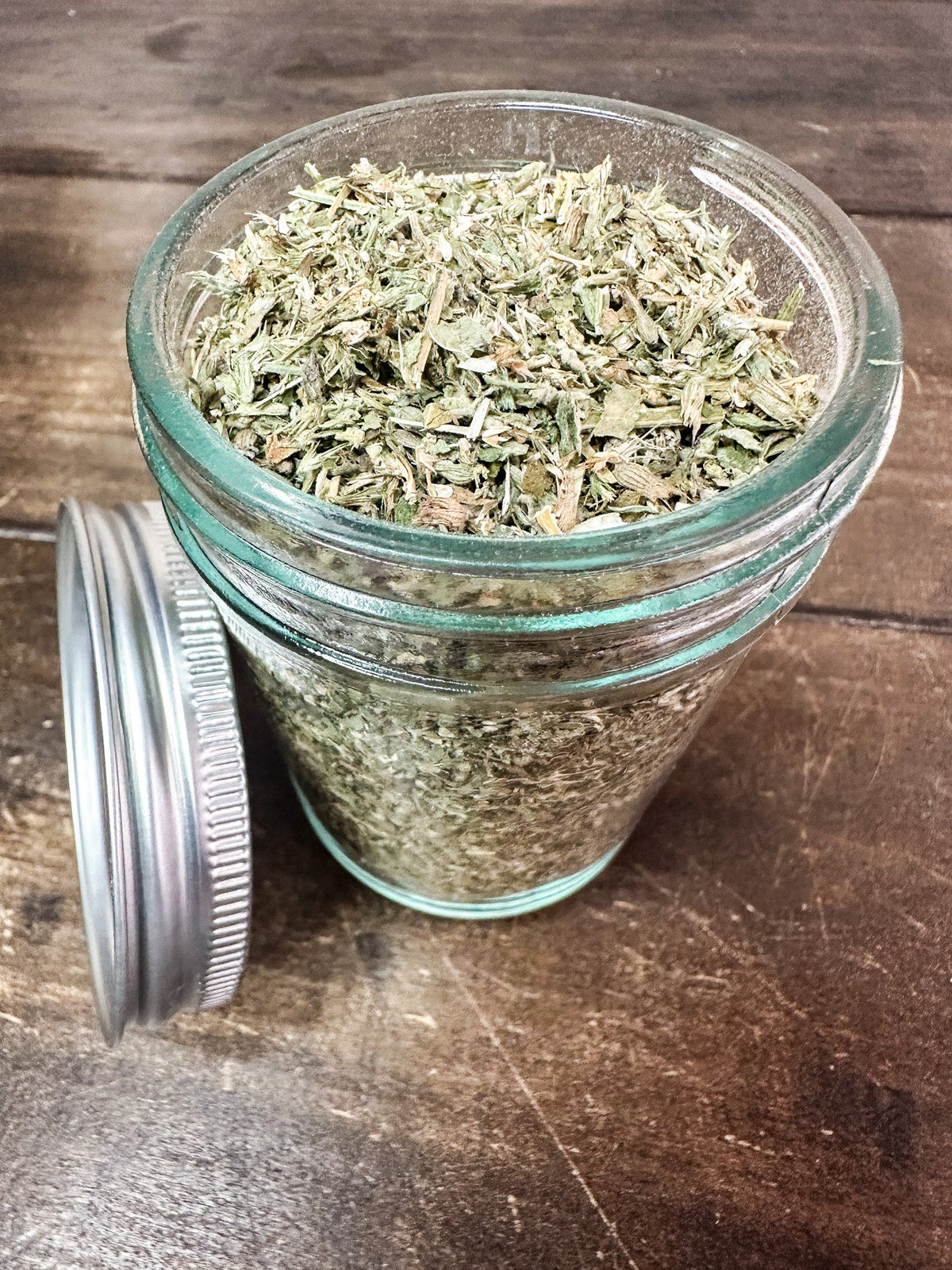Small jar of dried catnip herb from Herbalroseapothecary, showcasing a clear glass jar with dried green catnip leaves inside.