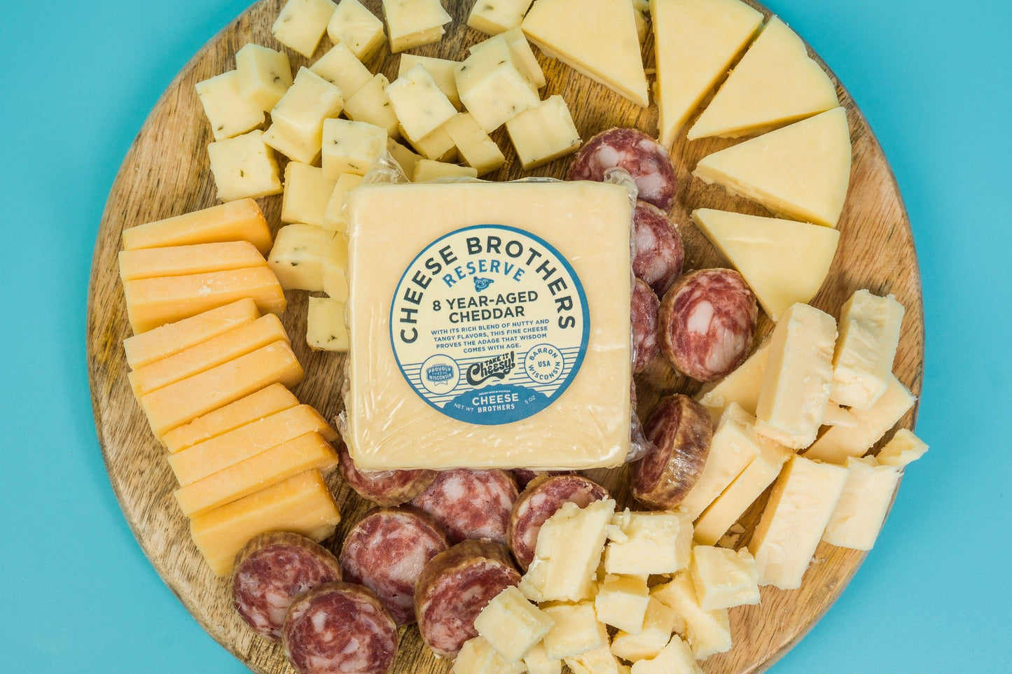 Cheese Brothers Deluxe Charcuterie Pack with assorted cured meats, cheeses, and accompaniments on a wooden board.