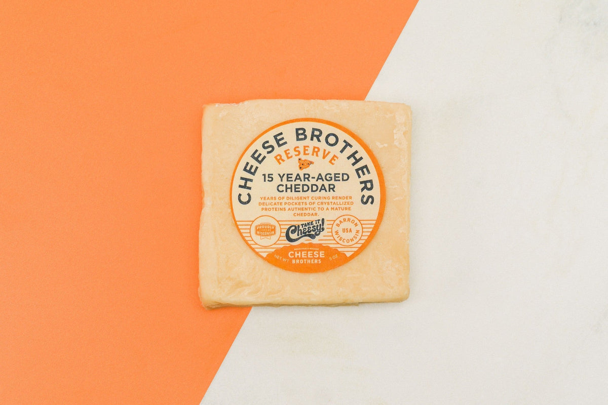 15-year-aged Cheddar cheese from Cheese Brothers, Inc., showcasing a firm, golden block of aged cheese with a rich texture.