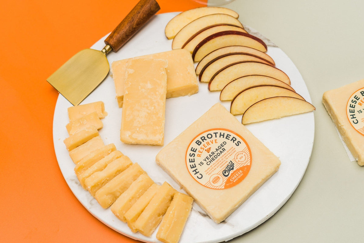 Aged 15-year cheddar cheese block from Cheese Brothers, Inc., with a firm texture and rich, golden color.