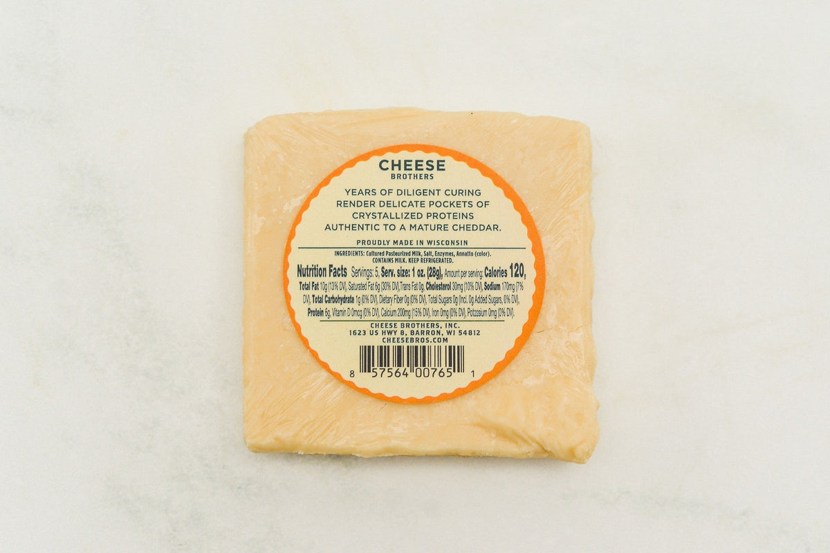 A block of 15-year-aged cheddar cheese from Cheese Brothers, Inc., showcasing its firm texture and rich golden color.