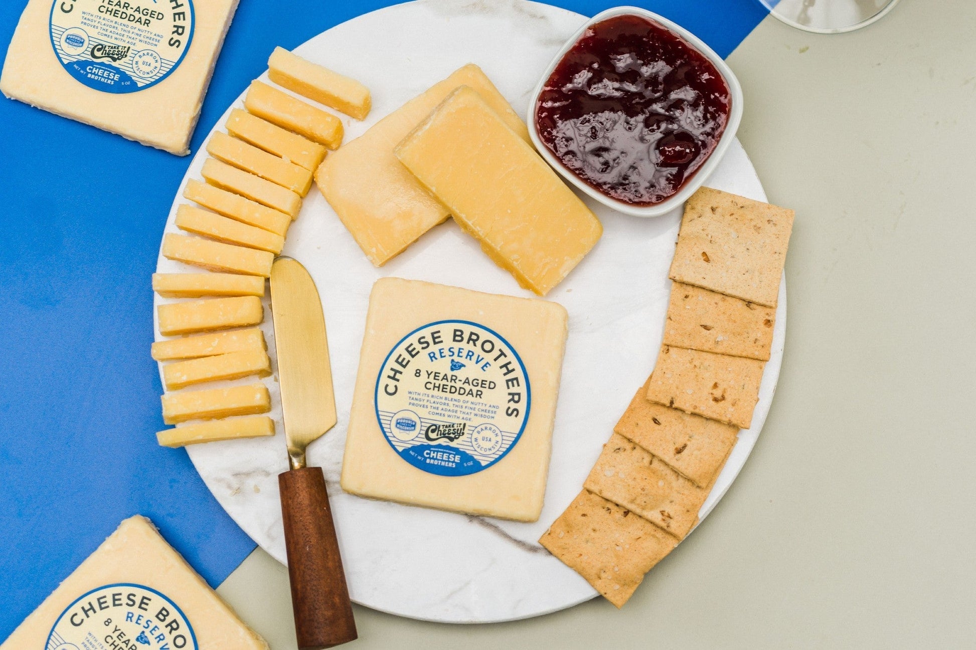 A block of 8-year-aged cheddar cheese from Cheese Brothers, Inc., showcasing its firm texture and rich, golden color.