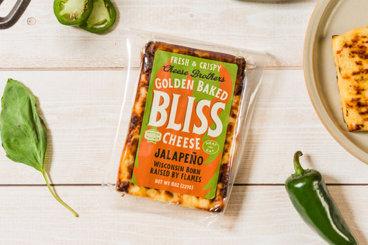 Golden baked cheese with jalapeño peppers from Cheese Brothers, Inc., showcasing a crispy, cheesy snack with spicy jalapeño slices.