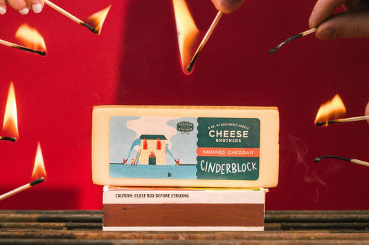 Smoked Cheddar cheese block from Cheese Brothers, Inc., showcasing its rich, smoky flavor and smooth, yellow-orange texture.