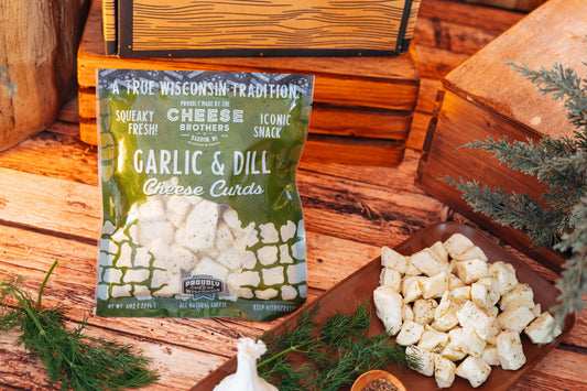 Garlic and dill cheese curds from Cheese Brothers, Inc., showcasing fresh, creamy cheese curds with herbs in a pack.