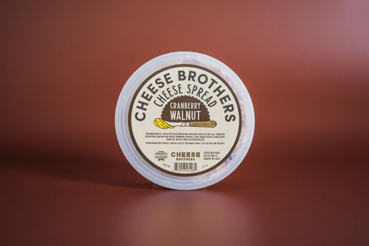 Cranberry Walnut Cheese Spread by Cheese Brothers, Inc. served on a cheese platter with cranberries and walnuts.