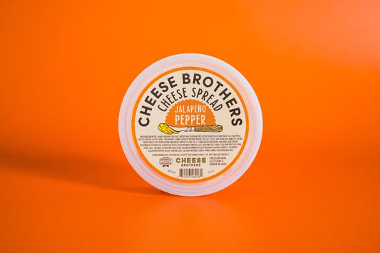 Jalapeño pepper cheese spread by Cheese Brothers, Inc., creamy cheese with spicy jalapeño peppers, in a jar.