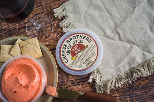 Creamy Port Wine Cheese Spread by Cheese Brothers, Inc., with a smooth texture and rich port wine flavor in a cheese spread container.