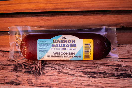Slices of Barron Sausage Co. Summer Sausage, a savory cured meat from Cheese Brothers, Inc., displayed on a cutting board.