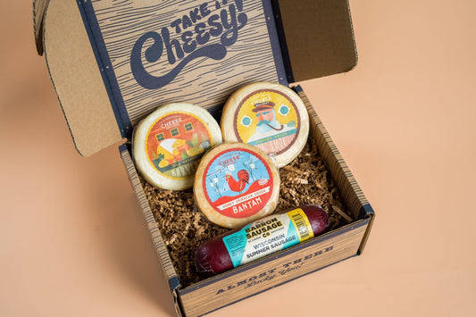 Cheese Brothers Inc. Cheese & Sausage Sampler 4-Pack with assorted cheeses and sausages arranged on a wooden platter.