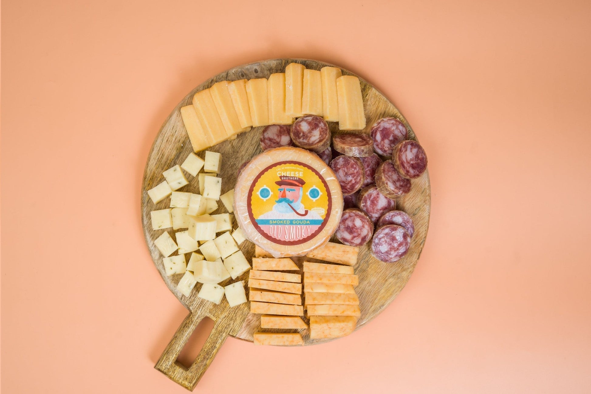 Cheese Brothers Inc. Cheese & Sausage Sampler 4-Pack with assorted cheeses and sausages on a wooden platter.