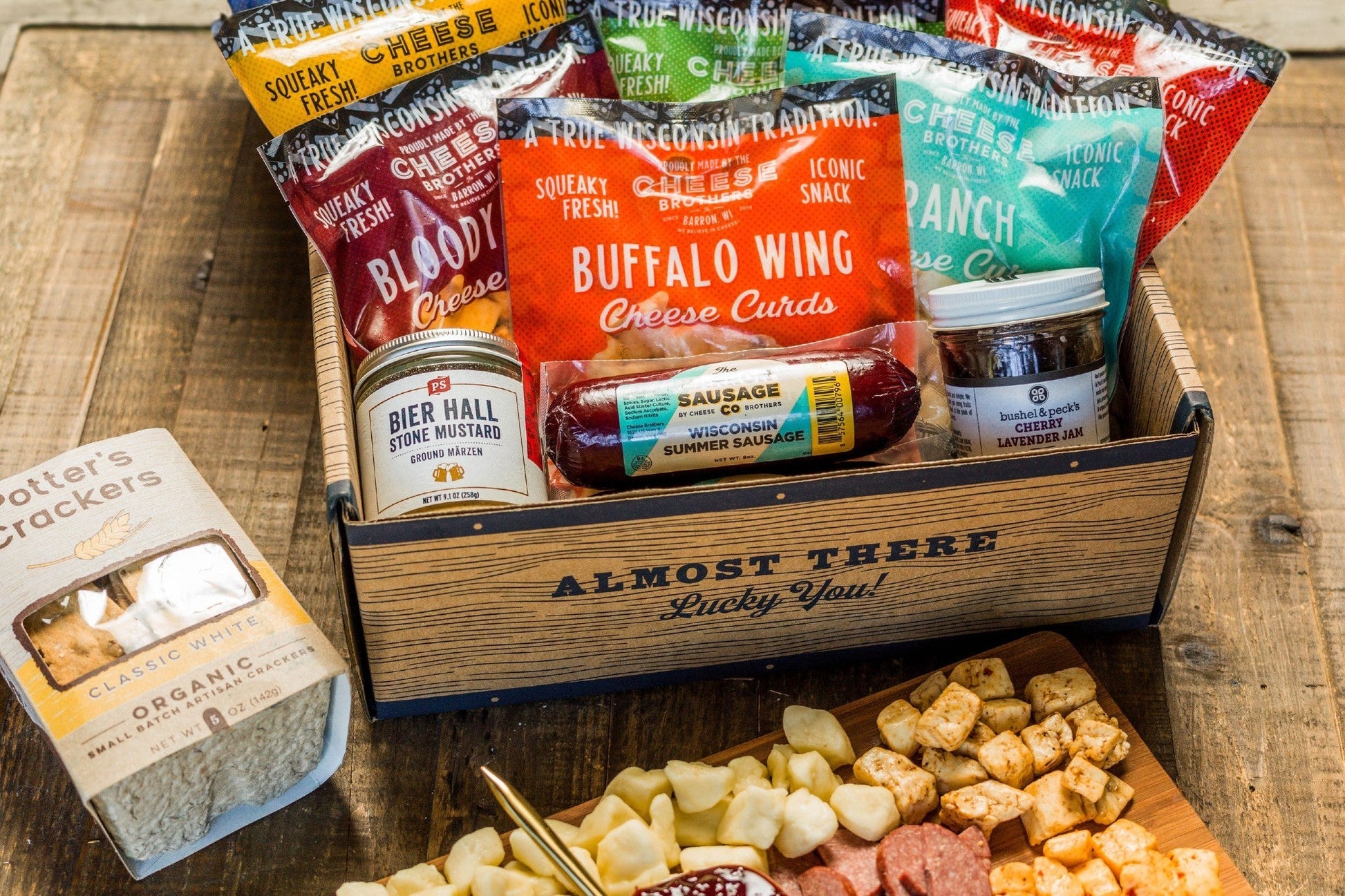Cheese Brothers Inc. Deluxe Char-Curd-Erie Box featuring assorted cheeses, charcuterie, and gourmet accompaniments in an elegant gift bundle.
