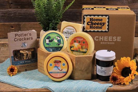 Cheese Brothers, Inc. housewarming gift basket with assorted cheeses, crackers, and accompaniments in a gift bundle.