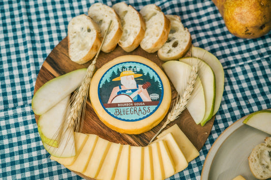 Creamy Bluegrass Bourbon Gouda cheese from Cheese Brothers, Inc., showing a wedge of rich, flavorful Gouda with a smooth texture.