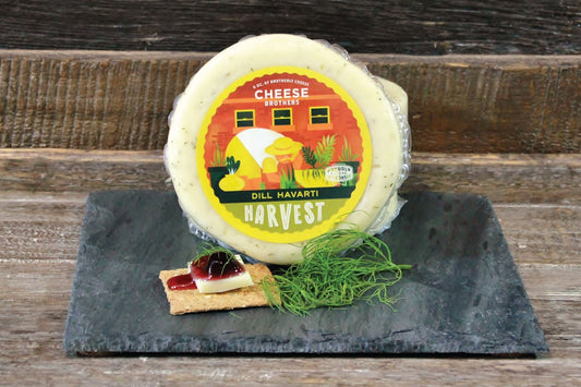 Creamy Dill Havarti cheese from Cheese Brothers, Inc., sliced and ready for serving with visible herbs and smooth texture.