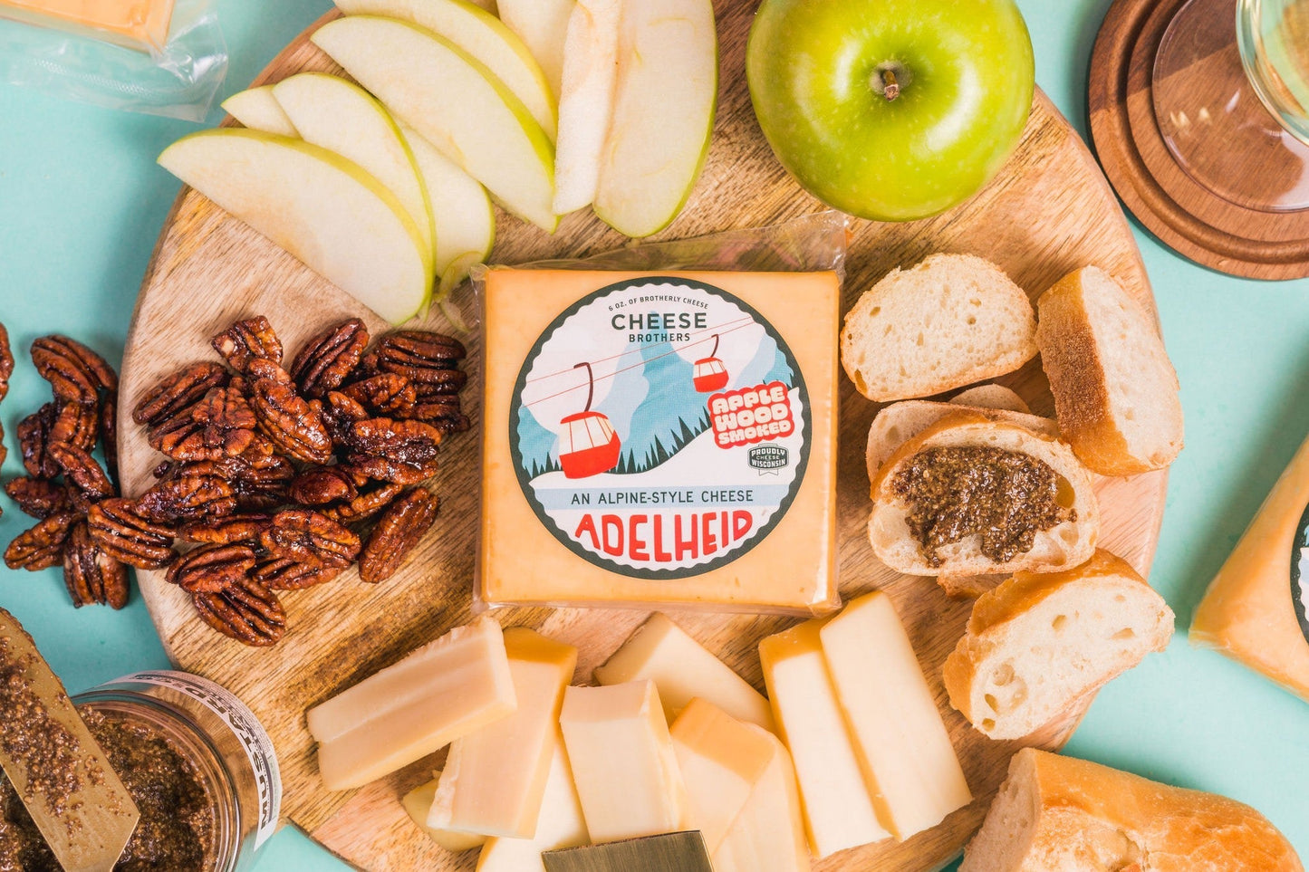 Smoked Adelheid Alpine-Style Cheese by Cheese Brothers, Inc., showcasing a wedge of this creamy, aged alpine cheese on a wooden board.