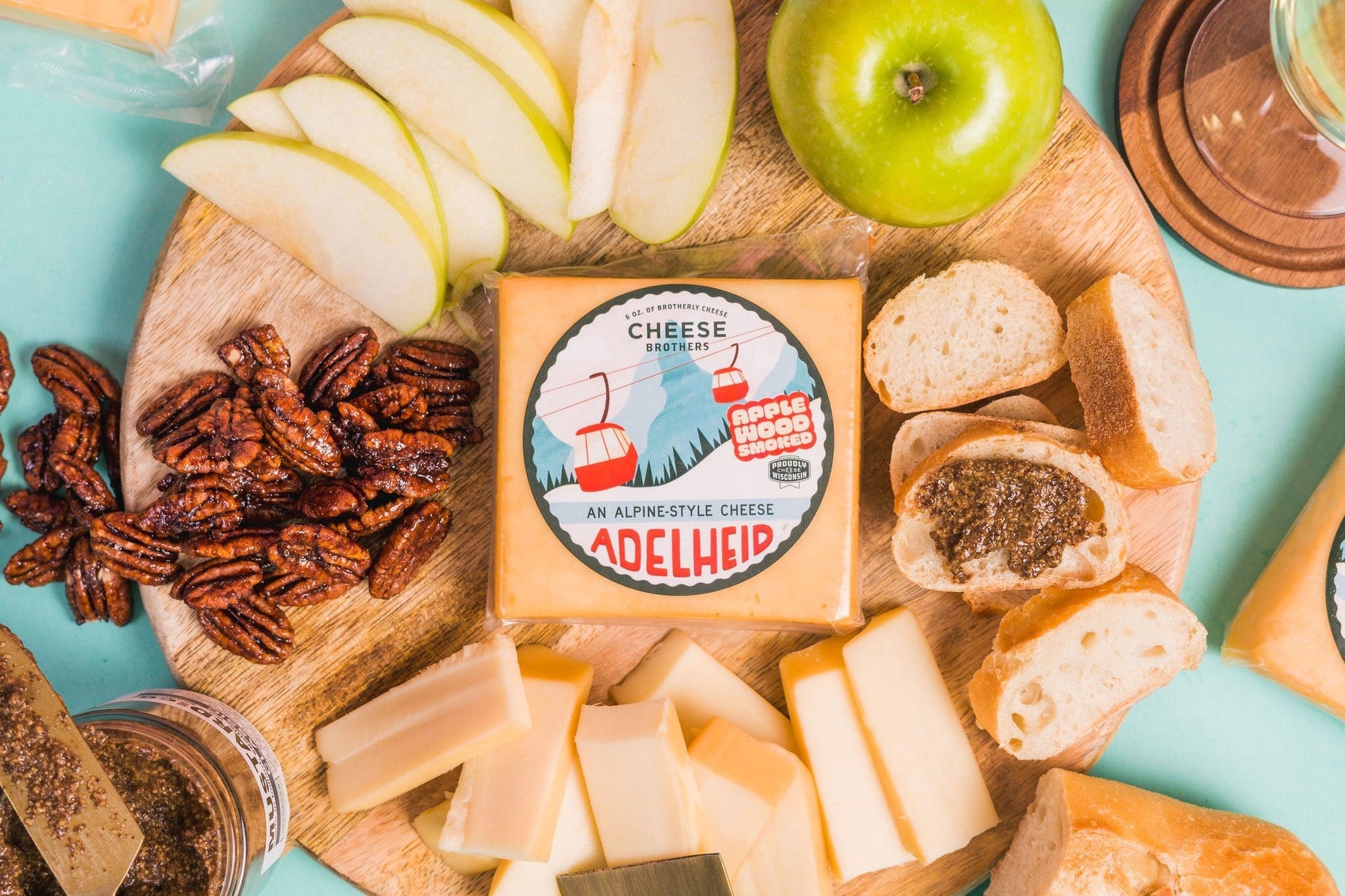 Smoked Adelheid Alpine-Style Cheese by Cheese Brothers, Inc., showcasing a wedge of this creamy, aged alpine cheese on a wooden board.