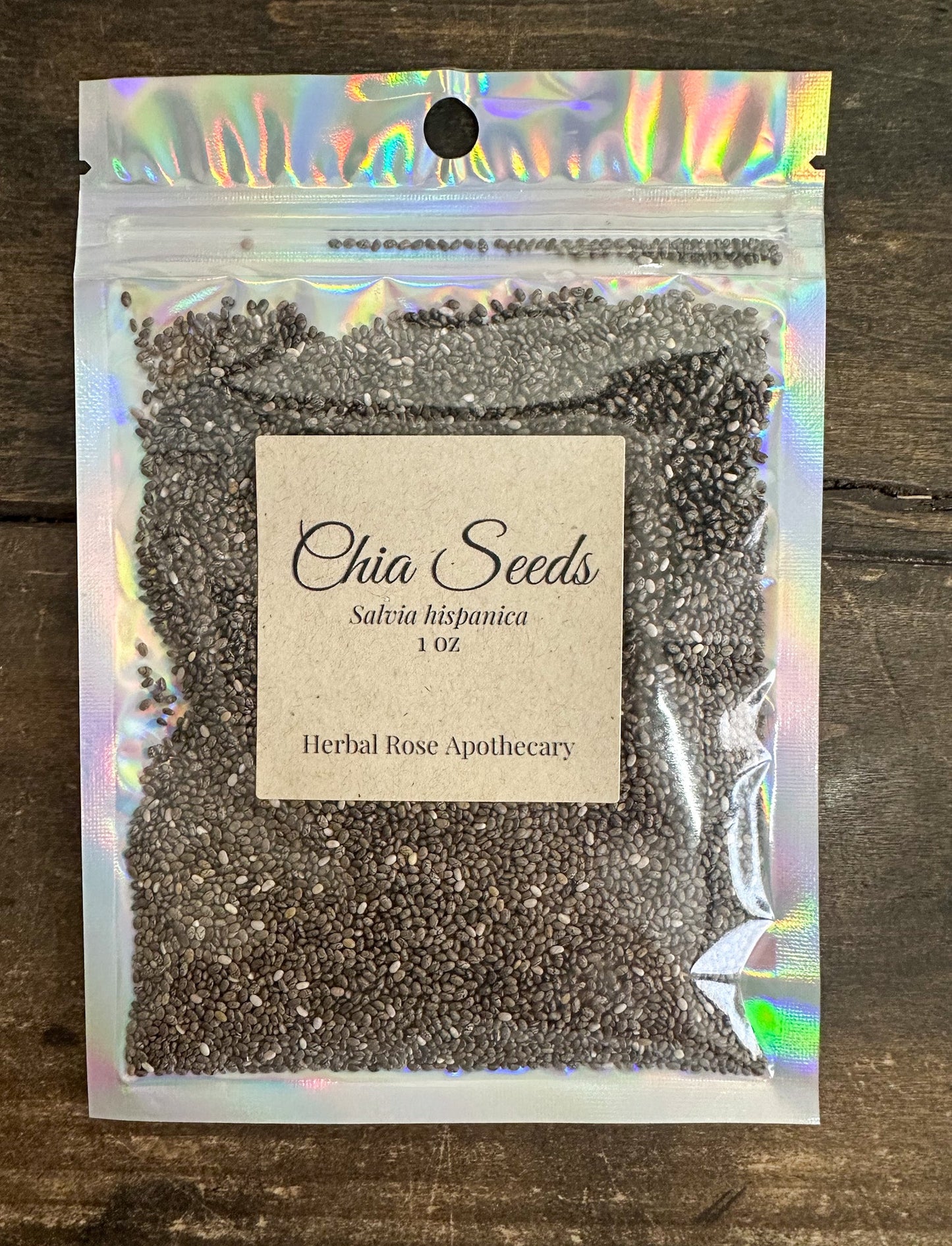Dried herbal chia seeds in a 1oz package from HerbalRoseApothecary, showing small, oval-shaped brown seeds in a clear container.