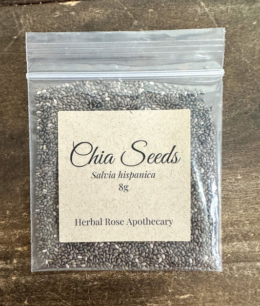 Dried chia seeds in a small glass jar, from Herbal Rose Apothecary, showing tiny, oval-shaped seeds with a matte surface.