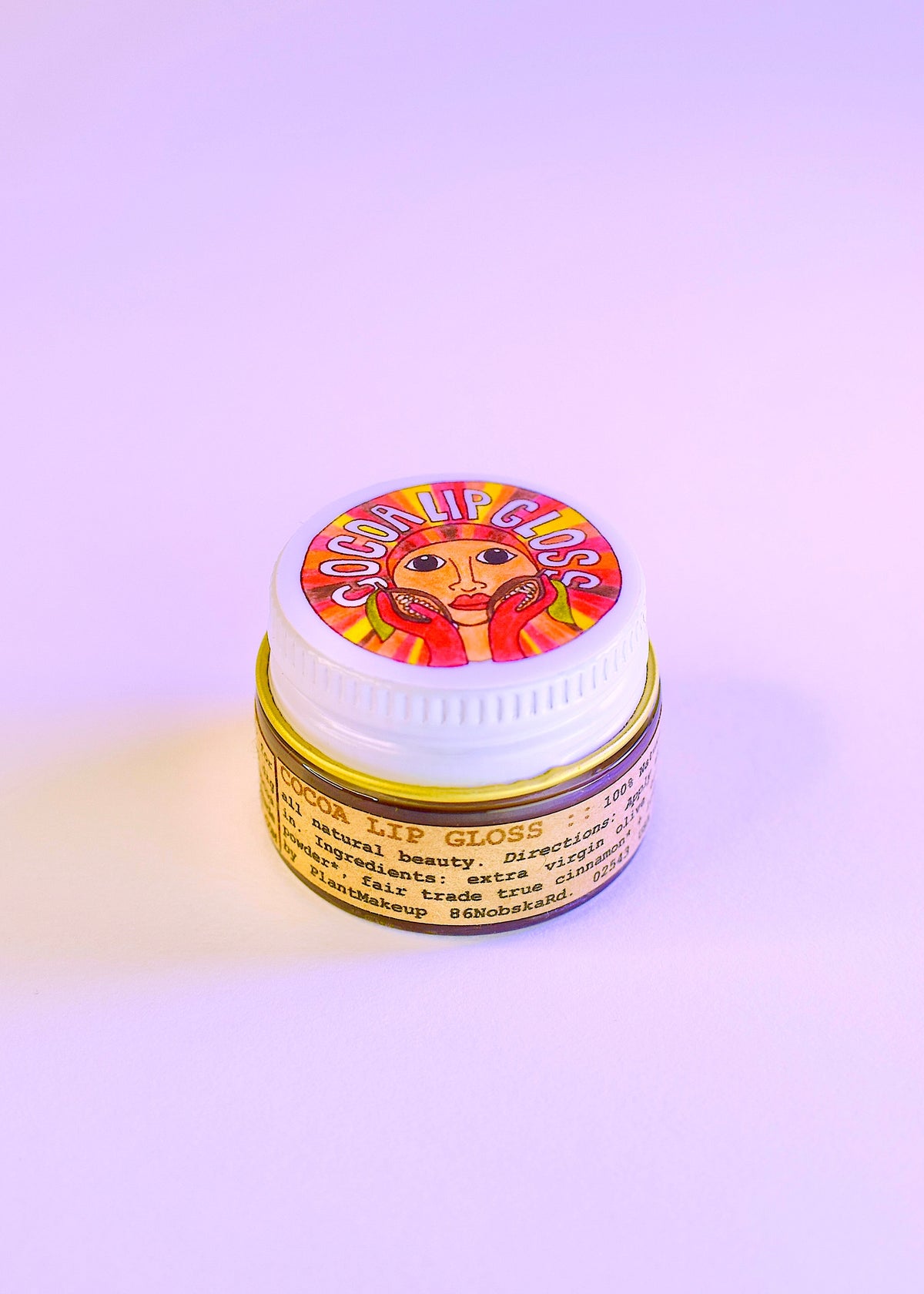 Plant Makeup Cocoa Lip Gloss tube with shiny, smooth cocoa-colored gloss on a white background.