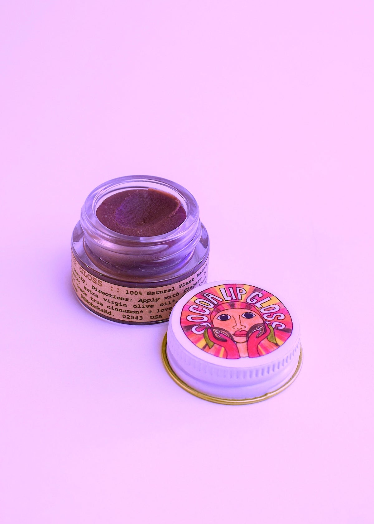 Plant Makeup Cocoa Lip Gloss in a clear tube with a glossy finish and a doe-foot applicator visible inside.